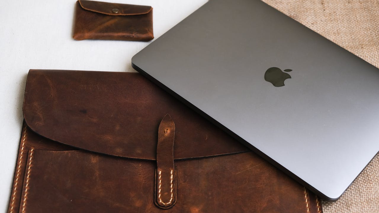 A sleek laptop with leather sleeve and pouch, perfect for stylish professionals.